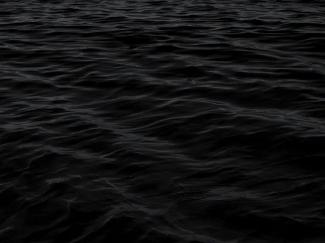Superfície de água escura com pequenas ondas